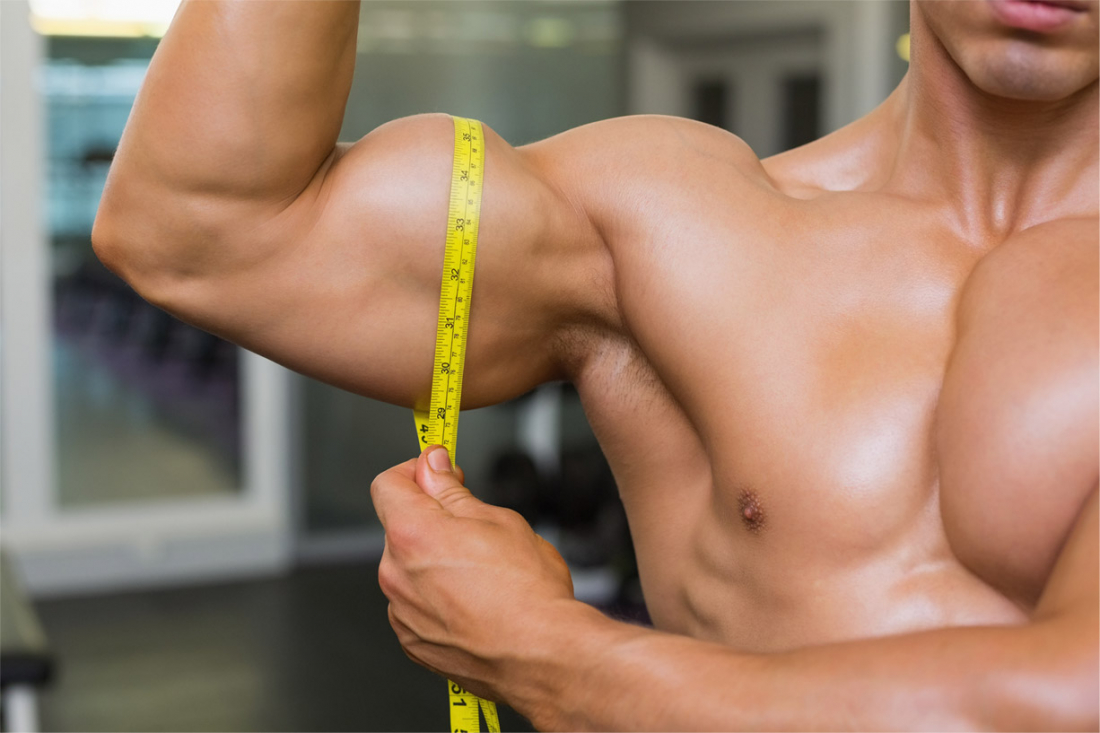 muž si měří biceps